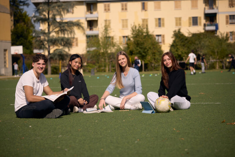 Studenti seduti sul prato del campus
