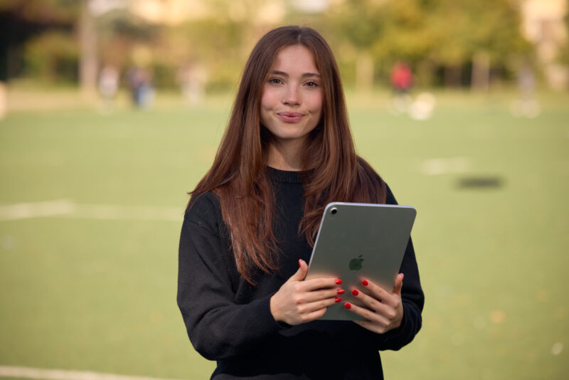 Studentessa con un tablet sul campo sportivo